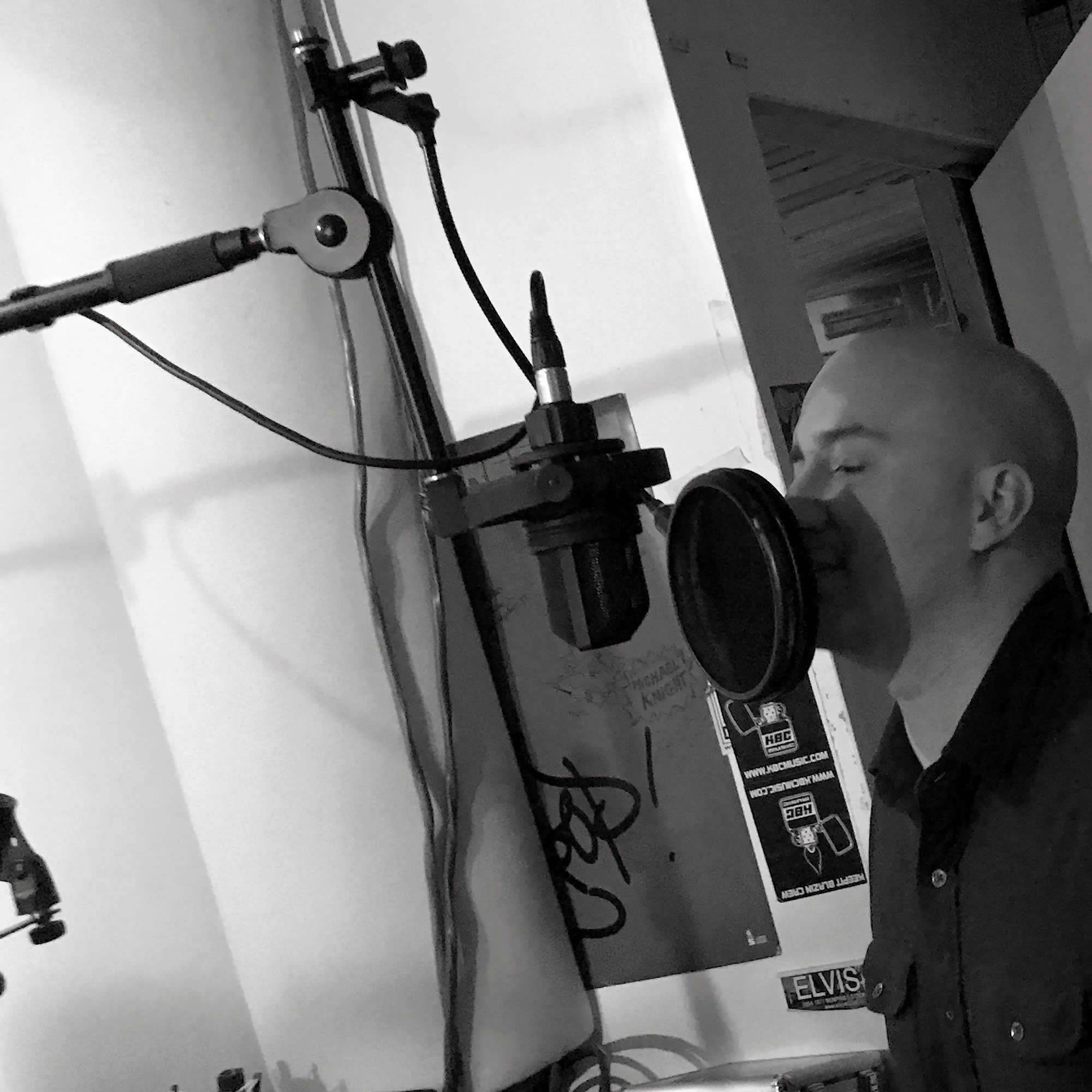 Jim Castro is singing in front of microsphone in Soundism's music studio